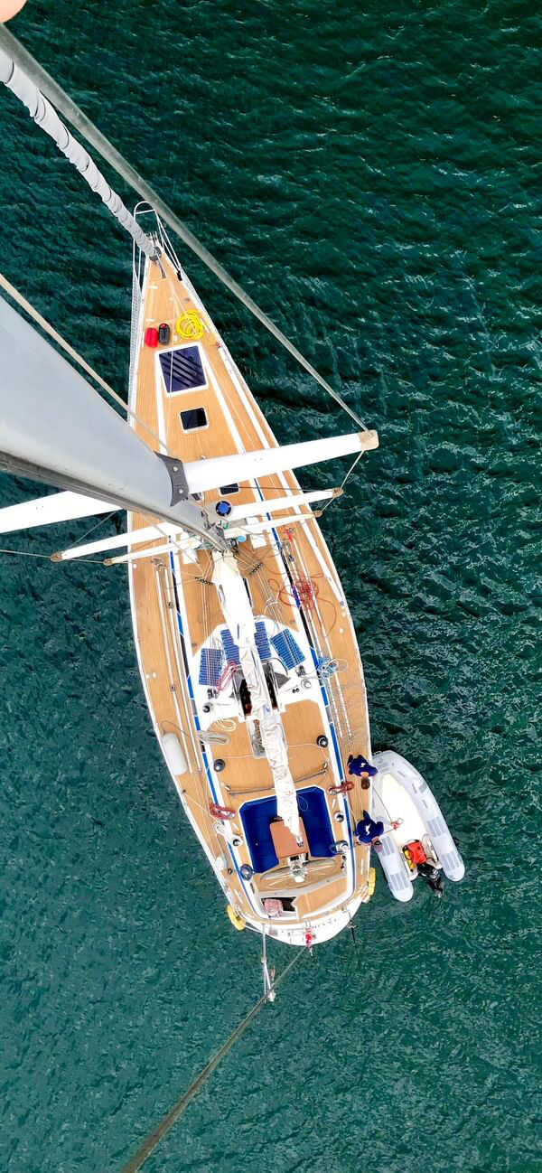 SY Cormorant seen from the top of the mast at anchor, with the tender alongside