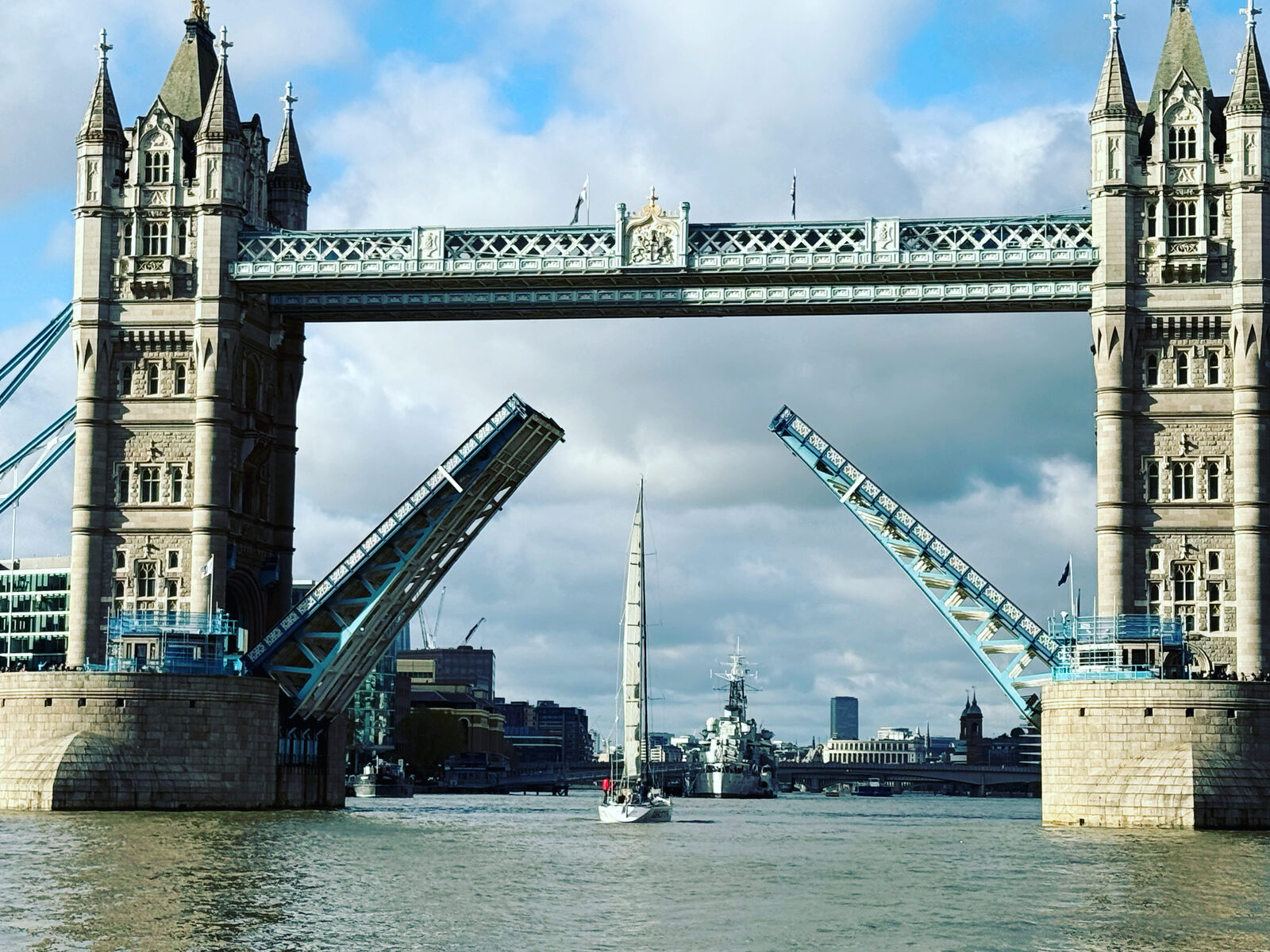 Tower Bridge lifting its bascules as a yacht sails through